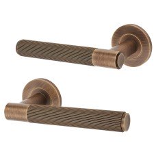 Alexander and Wilks Antique Brass Reeded Door Handles on Round Rose - Spitfire Range 